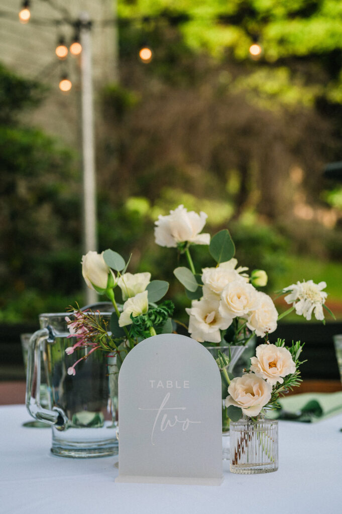 wedding reception decor with white and pink flowers and a table sign